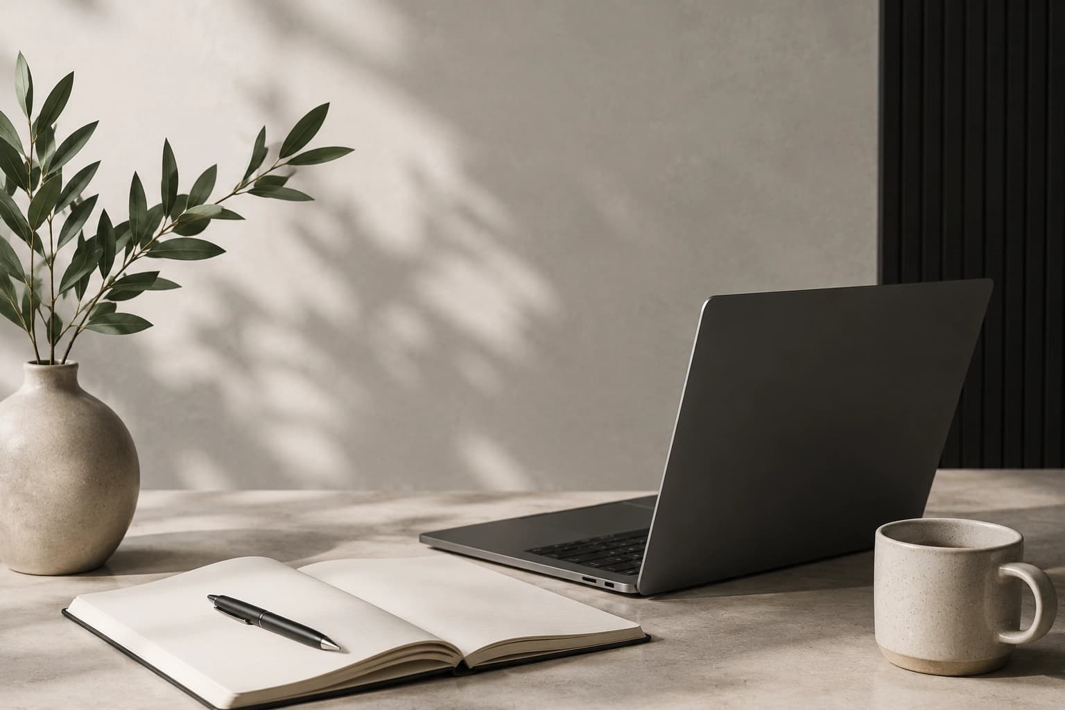 Laptop, notebook, plant, and coffee cup on a calm workspace desk