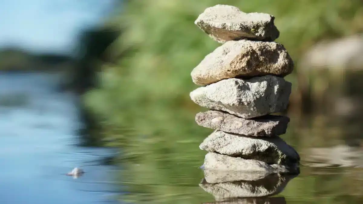 Balanced stones stacked in calm water, used as the Finding Your Haven case study header image
