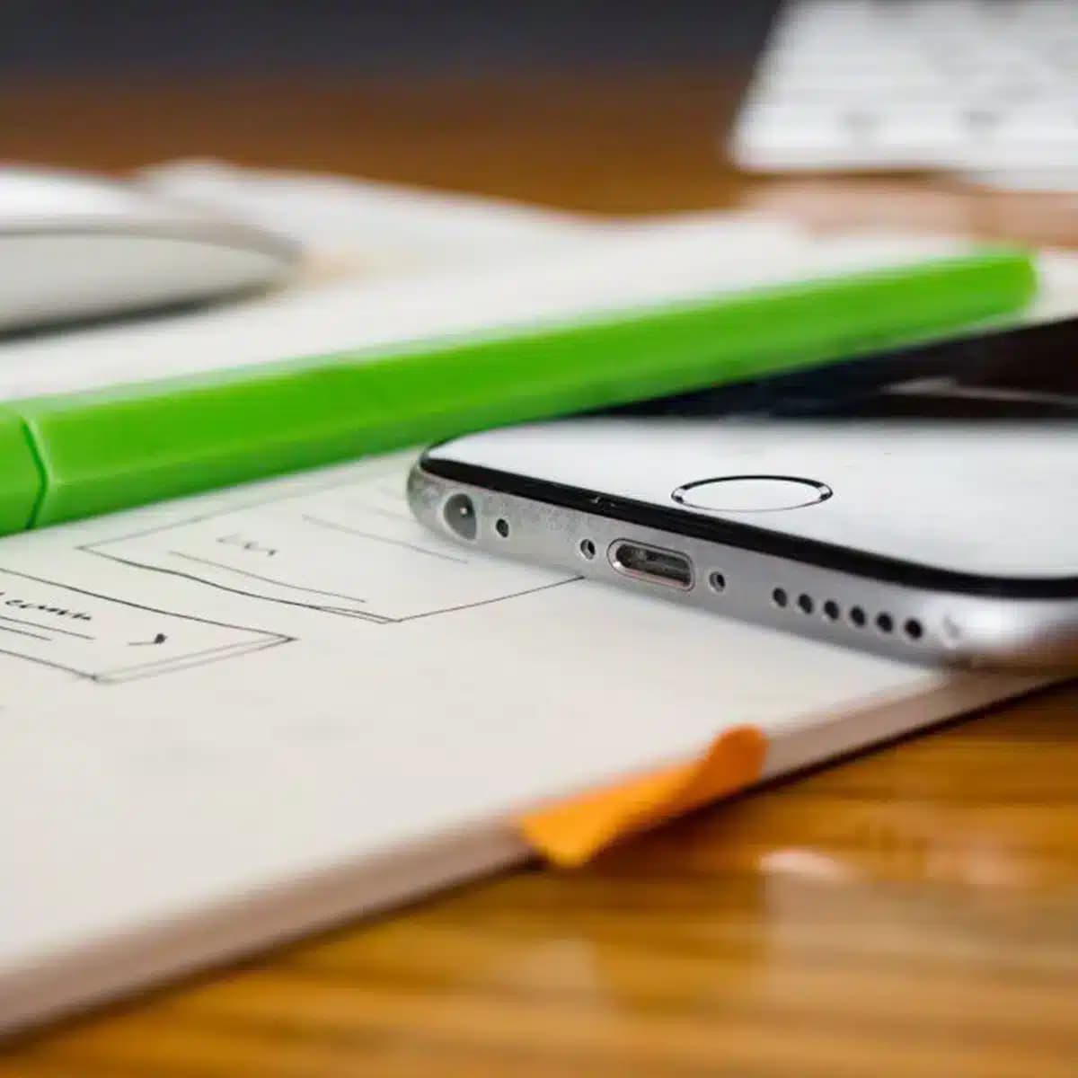 A close-up of digital design sketches and mobile interface planning on a desk