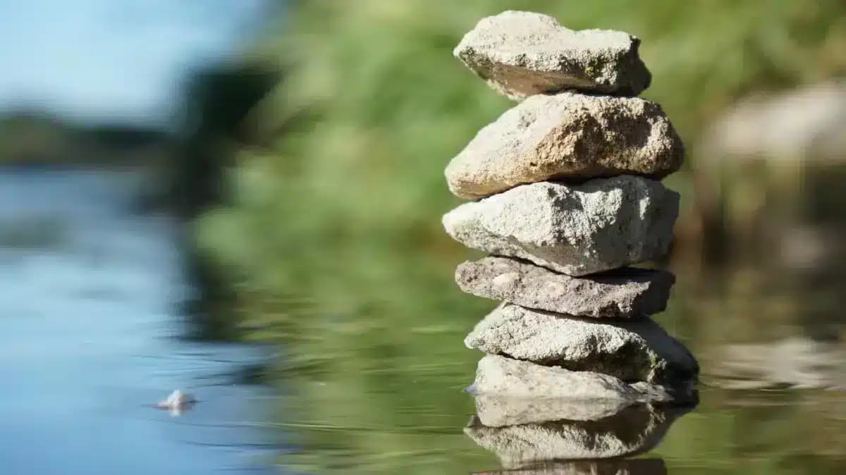 Balanced stones stacked in calm water, used as the Finding Your Haven case study header image
